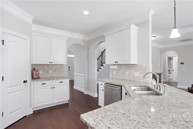 kitchen featuring arched walkways, a sink, stainless steel dishwasher, white cabinetry, and crown molding