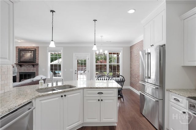 kitchen with stainless steel appliances, a sink, baseboards, dark wood-type flooring, and white cabinetry