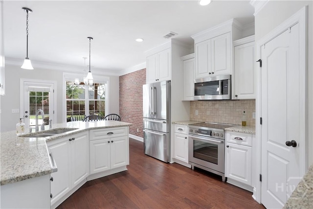 kitchen featuring appliances with stainless steel finishes, a sink, ornamental molding, a chandelier, and dark wood-type flooring