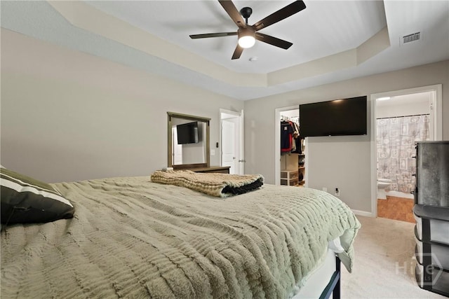 306 Madison Oaks Dr, Rincon, GA 31326 - carpeted bedroom with a walk in closet, a closet, a raised ceiling, ensuite bath, and a ceiling fan