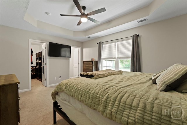 306 Madison Oaks Dr, Rincon, GA 31326 - bedroom with a tray ceiling, light carpet, baseboards, a spacious closet, and ceiling fan