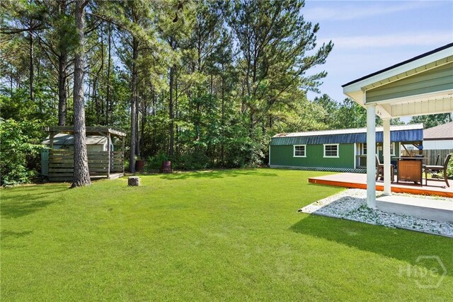 306 Madison Oaks Dr, Rincon, GA 31326 - view of grassy yard with a wooden deck and an outdoor structure