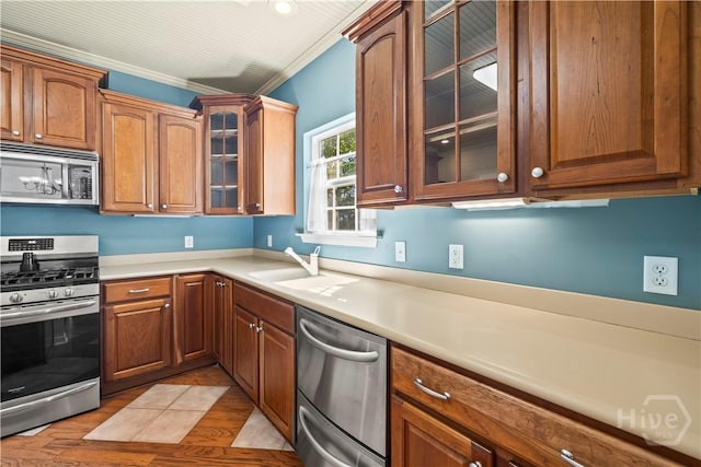303 Stonebridge Cir, Savannah, GA 31419 - kitchen with stainless steel appliances, ornamental molding, light countertops, a sink, and brown cabinets