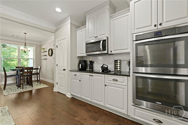 119 Greystone Dr, Guyton, GA 31312 - kitchen with appliances with stainless steel finishes, crown molding, a chandelier, baseboards, and white cabinetry