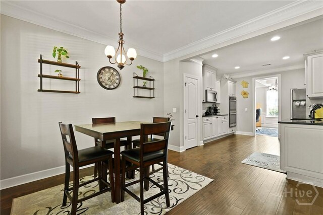 119 Greystone Dr, Guyton, GA 31312 - dining room featuring crown molding, recessed lighting, dark wood-type flooring, a chandelier, and baseboards