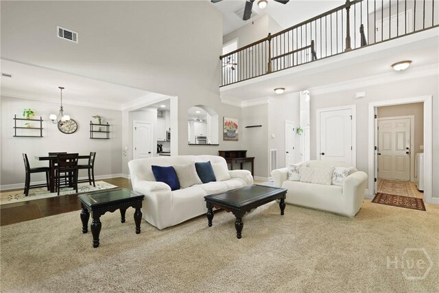 119 Greystone Dr, Guyton, GA 31312 - carpeted living room with baseboards, a chandelier, a towering ceiling, ceiling fan, and ornamental molding