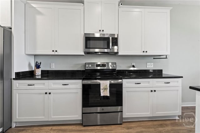 216 Cypress Lakes Dr, Bloomingdale, GA 31302 - kitchen featuring appliances with stainless steel finishes, white cabinets, wood finished floors, and dark stone countertops