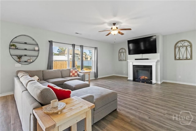 216 Cypress Lakes Dr, Bloomingdale, GA 31302 - living room featuring a ceiling fan, baseboards, wood finished floors, and a lit fireplace