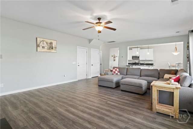 216 Cypress Lakes Dr, Bloomingdale, GA 31302 - living area featuring a ceiling fan, dark wood-style flooring, and baseboards