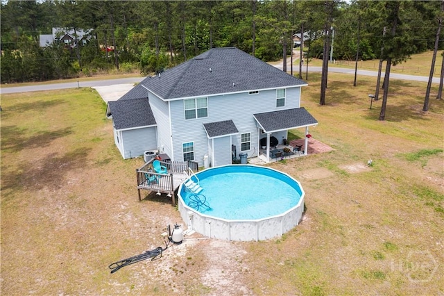 98 Vickers Rd SE, Ludowici, GA 31316 - back of house with roof with shingles, an outdoor pool, a yard, and a deck
