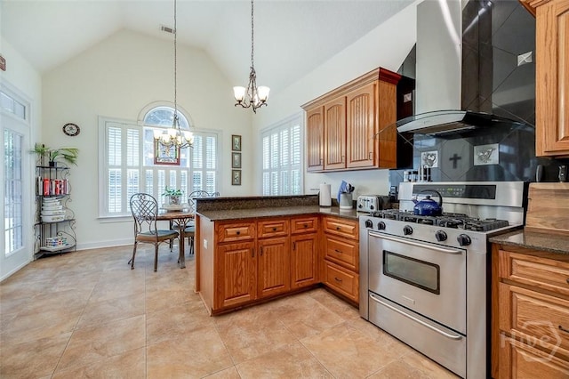 2 N Camellia Ct, Guyton, GA 31312 - kitchen with stainless steel range with gas stovetop, wall chimney exhaust hood, a chandelier, brown cabinets, and a peninsula