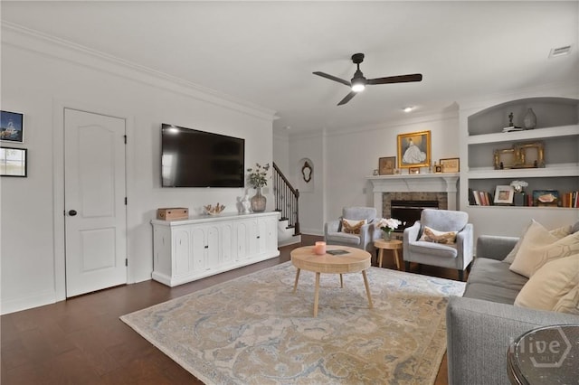 447 Walthour Dr, Rincon, GA 31326 - living room with stairway, dark wood-type flooring, a fireplace, ornamental molding, and a ceiling fan