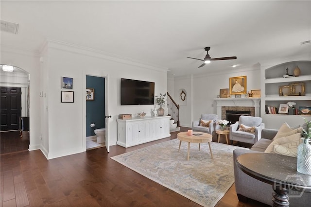 447 Walthour Dr, Rincon, GA 31326 - living area featuring crown molding, a fireplace, a ceiling fan, stairs, and dark wood-type flooring