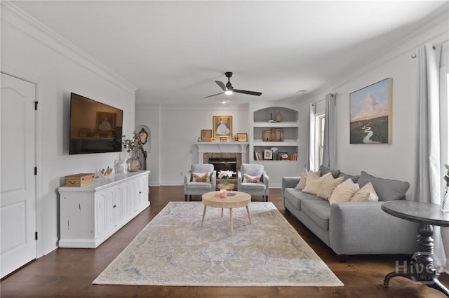 447 Walthour Dr, Rincon, GA 31326 - living room featuring ceiling fan, built in shelves, plenty of natural light, a glass covered fireplace, and ornamental molding