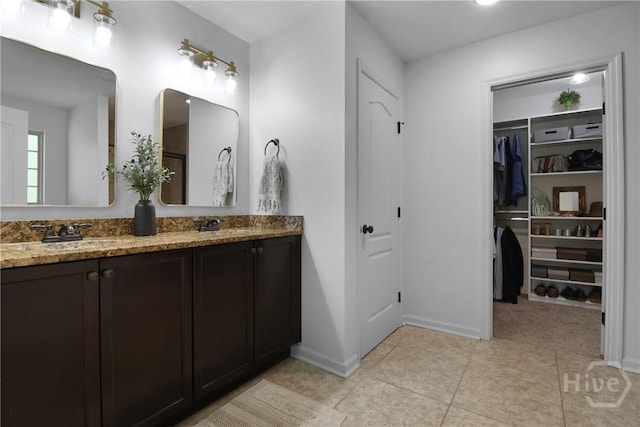 447 Walthour Dr, Rincon, GA 31326 - bathroom featuring double vanity, tile patterned flooring, baseboards, and a walk in closet