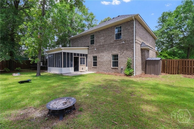 447 Walthour Dr, Rincon, GA 31326 - rear view of property featuring a sunroom, brick siding, an outdoor fire pit, and a patio area
