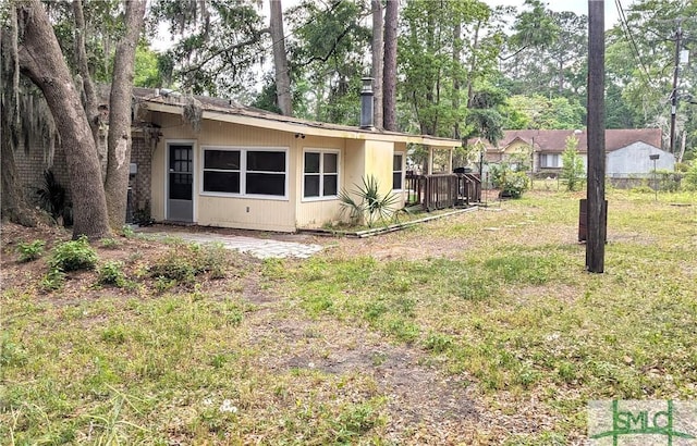 rear view of property featuring a lawn