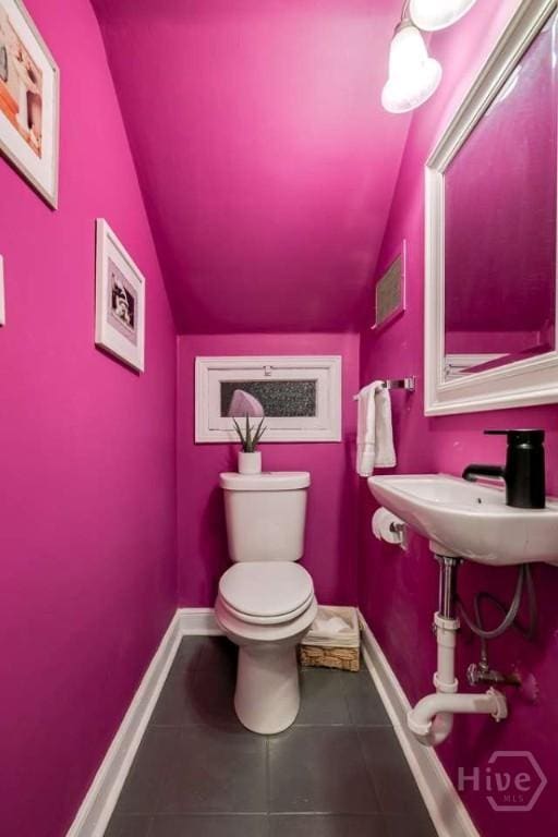 3600 Abercorn St, Savannah, GA 31405 - bathroom with vaulted ceiling, toilet, tile patterned flooring, baseboards, and a sink