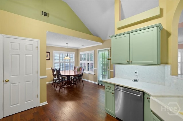 kitchen featuring green cabinetry, stainless steel dishwasher, vaulted ceiling, light countertops, and dark wood-style floors