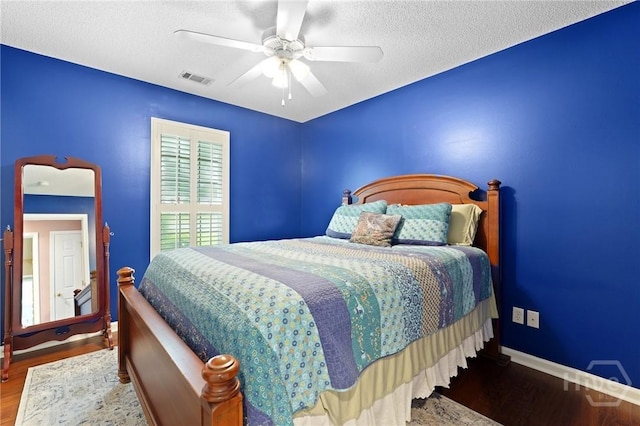 bedroom with wood finished floors, a textured ceiling, ceiling fan, and baseboards