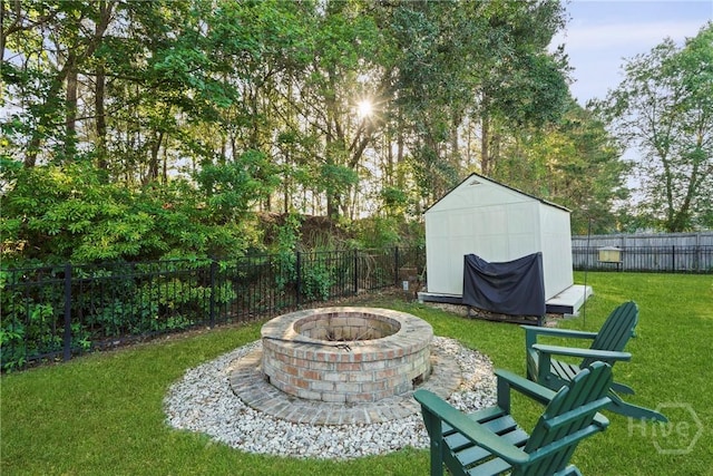 view of yard featuring a fire pit, a storage shed, and an outbuilding