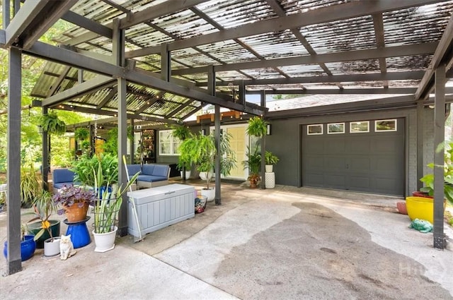 view of patio with a pergola, outdoor lounge area, driveway, and an attached garage