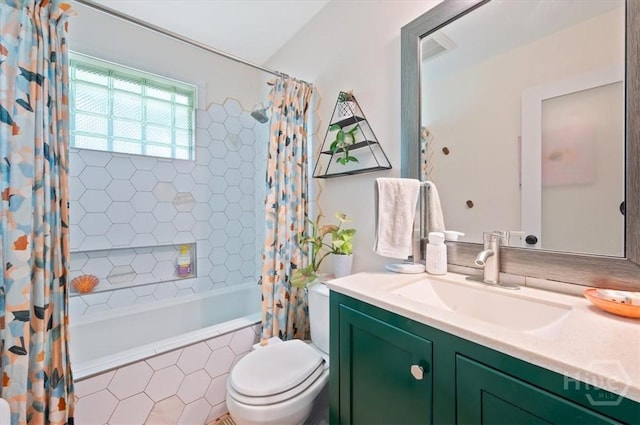full bathroom featuring tiled shower / bath combo, toilet, and vanity