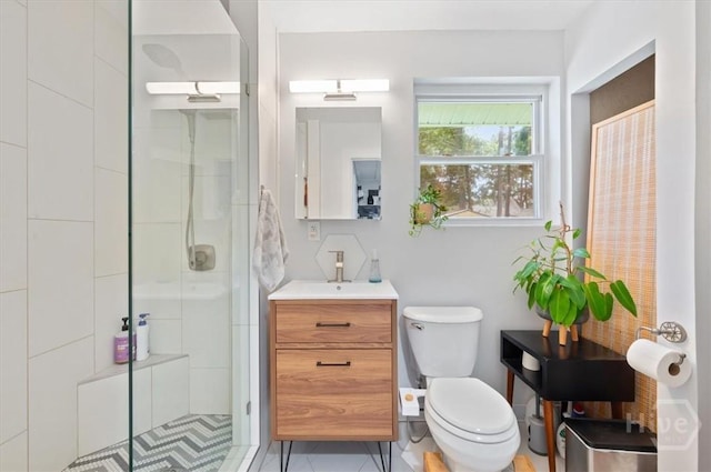 full bath featuring a stall shower, toilet, vanity, and tile patterned flooring