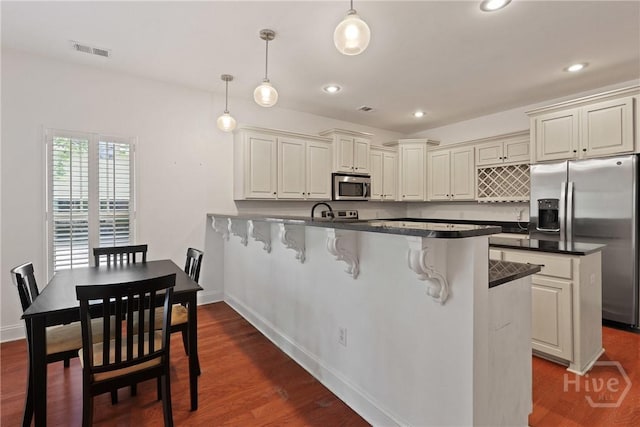 90 Golden Rod Loop, Richmond Hill, GA 31324 - kitchen featuring stainless steel appliances, a peninsula, a kitchen bar, baseboards, and recessed lighting