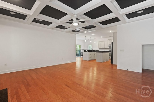 90 Golden Rod Loop, Richmond Hill, GA 31324 - unfurnished living room featuring coffered ceiling, light wood-style flooring, baseboards, and beamed ceiling