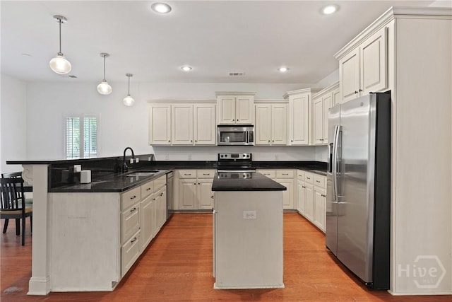 90 Golden Rod Loop, Richmond Hill, GA 31324 - kitchen with appliances with stainless steel finishes, a sink, a peninsula, a center island, and dark countertops