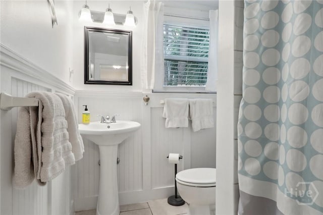 1212 2nd Ave, Tybee Island, GA 31328 - bathroom featuring toilet, a shower with curtain, and tile patterned floors