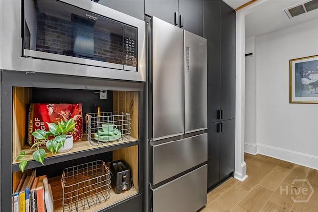 321 Abercorn St Unit 404, Savannah, GA 31401 - kitchen with stainless steel appliances, dark cabinets, baseboards, and light wood finished floors