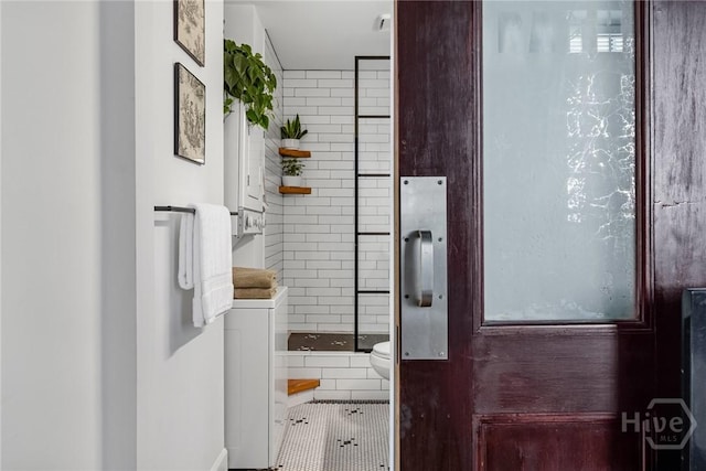 321 Abercorn St Unit 404, Savannah, GA 31401 - full bathroom featuring a shower stall, tile patterned flooring, toilet, baseboards, and washer / clothes dryer