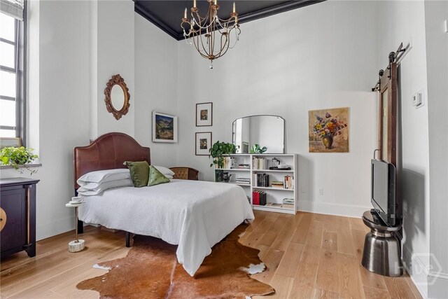 321 Abercorn St Unit 404, Savannah, GA 31401 - bedroom featuring a chandelier, a towering ceiling, wood finished floors, a barn door, and baseboards