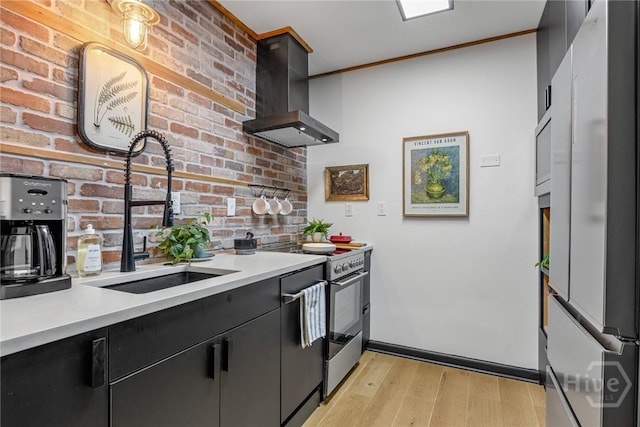 321 Abercorn St Unit 404, Savannah, GA 31401 - kitchen featuring freestanding refrigerator, a sink, wall chimney range hood, light countertops, and dark cabinets
