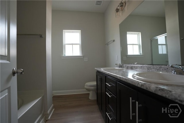 141 Mcclelland Loop NE, Ludowici, GA 31316 - full bath with healthy amount of natural light, wood finished floors, toilet, and double vanity