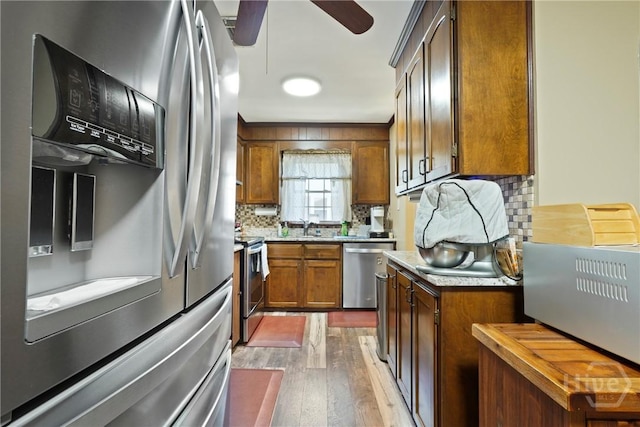3010 Leonard St, Savannah, GA 31404 - kitchen featuring stainless steel appliances, dark wood-style flooring, decorative backsplash, a sink, and ceiling fan