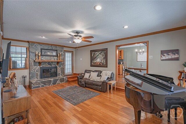 116 Deerfield Dr, Springfield, GA 31329 - living room featuring crown molding, a textured ceiling, wood finished floors, a stone fireplace, and ceiling fan