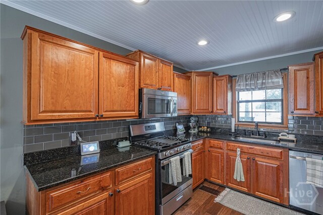 116 Deerfield Dr, Springfield, GA 31329 - kitchen featuring appliances with stainless steel finishes, a sink, brown cabinetry, dark stone counters, and ornamental molding