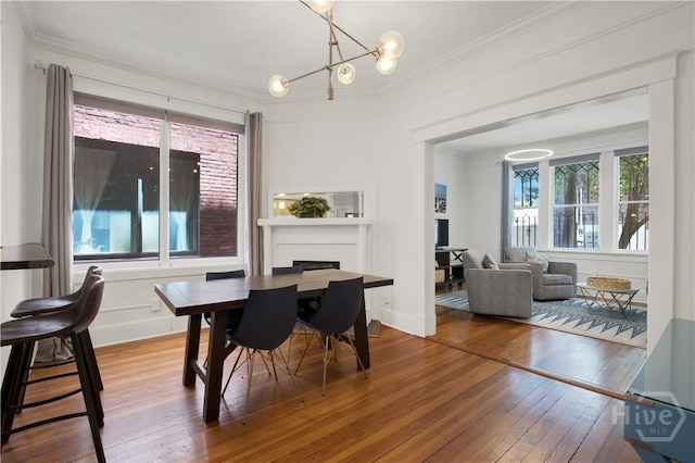 117 Lincoln St Unit 4A, Savannah, GA 31401 - dining space featuring ornamental molding, hardwood / wood-style flooring, a fireplace, and a chandelier