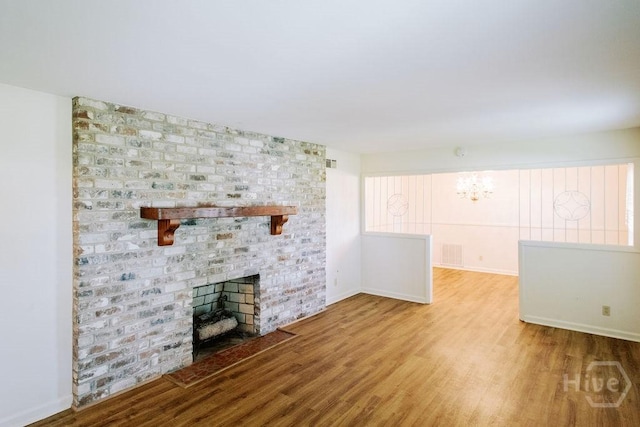 1 Broadmoor Cir, Savannah, GA 31406 - unfurnished living room featuring wood finished floors, a chandelier, a fireplace, and baseboards