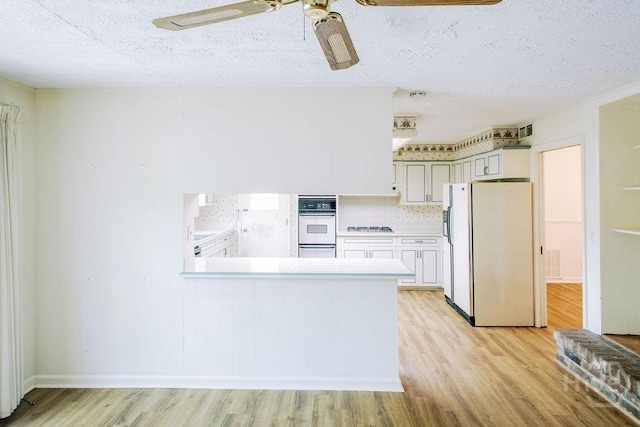 1 Broadmoor Cir, Savannah, GA 31406 - kitchen with white appliances, light wood-type flooring, a ceiling fan, light countertops, and a textured ceiling