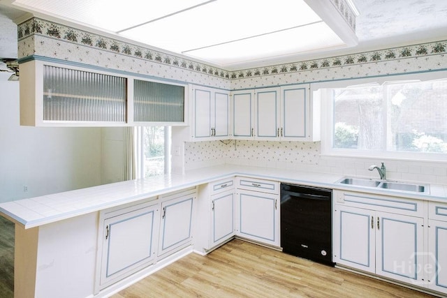 1 Broadmoor Cir, Savannah, GA 31406 - kitchen with black dishwasher, a sink, a peninsula, light wood-type flooring, and decorative backsplash