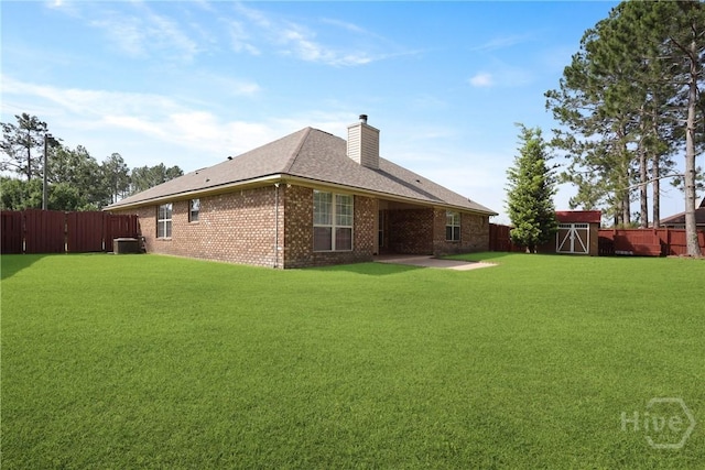 1919 Bluestone Loop, Hinesville, GA 31313 - back of house featuring a chimney, brick siding, a storage unit, an outdoor structure, and central air condition unit