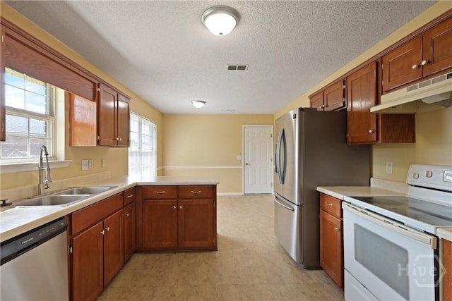1919 Bluestone Loop, Hinesville, GA 31313 - kitchen featuring appliances with stainless steel finishes, under cabinet range hood, a sink, light countertops, and a peninsula
