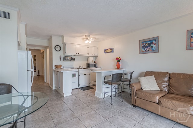 1217 Bay St Unit 107B, Tybee Island, GA 31328 - living room featuring light tile patterned floors, ceiling fan, and a textured ceiling