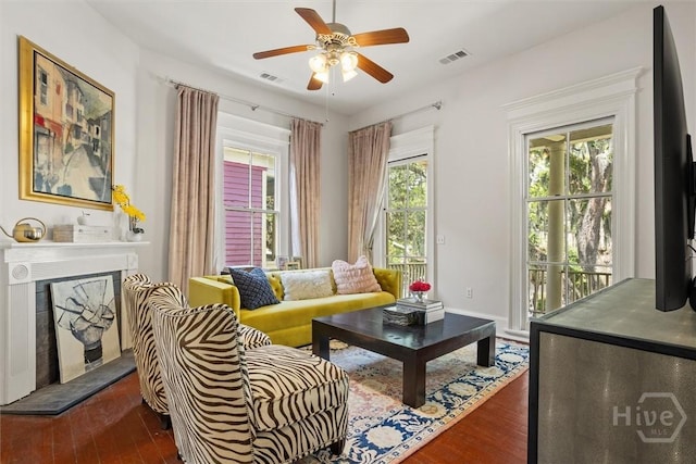 1722/1724 Barnard St, Savannah, GA 31401 - living room featuring dark wood-type flooring, a fireplace with raised hearth, ceiling fan, and baseboards