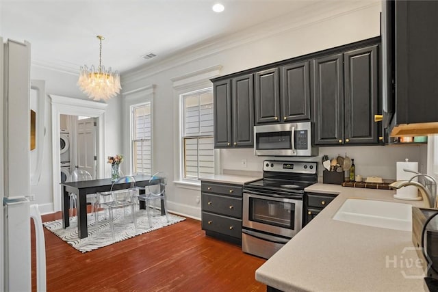 1722/1724 Barnard St, Savannah, GA 31401 - kitchen with appliances with stainless steel finishes, stacked washer / drying machine, a sink, light countertops, and crown molding