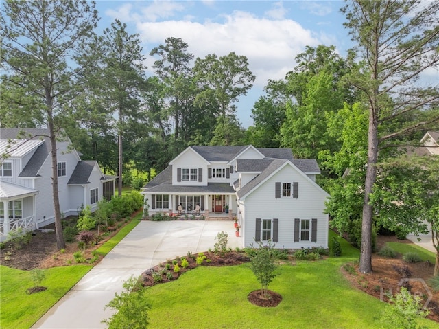 124 Kent Trl, Pooler, GA 31322 - traditional-style home with concrete driveway, a front yard, a porch, roof with shingles, and view of scattered trees